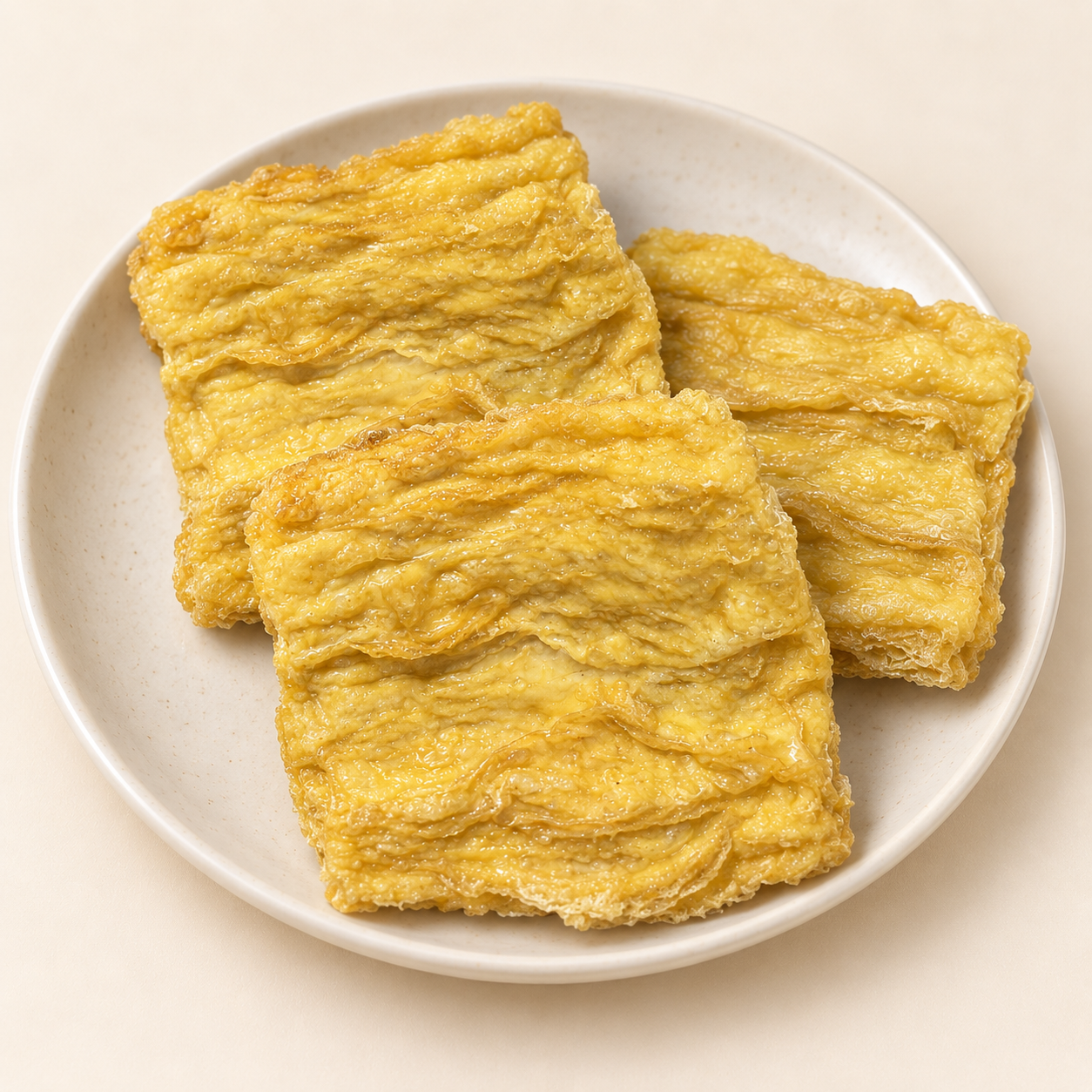 淺色盤中三片金黃色方形炸豆包